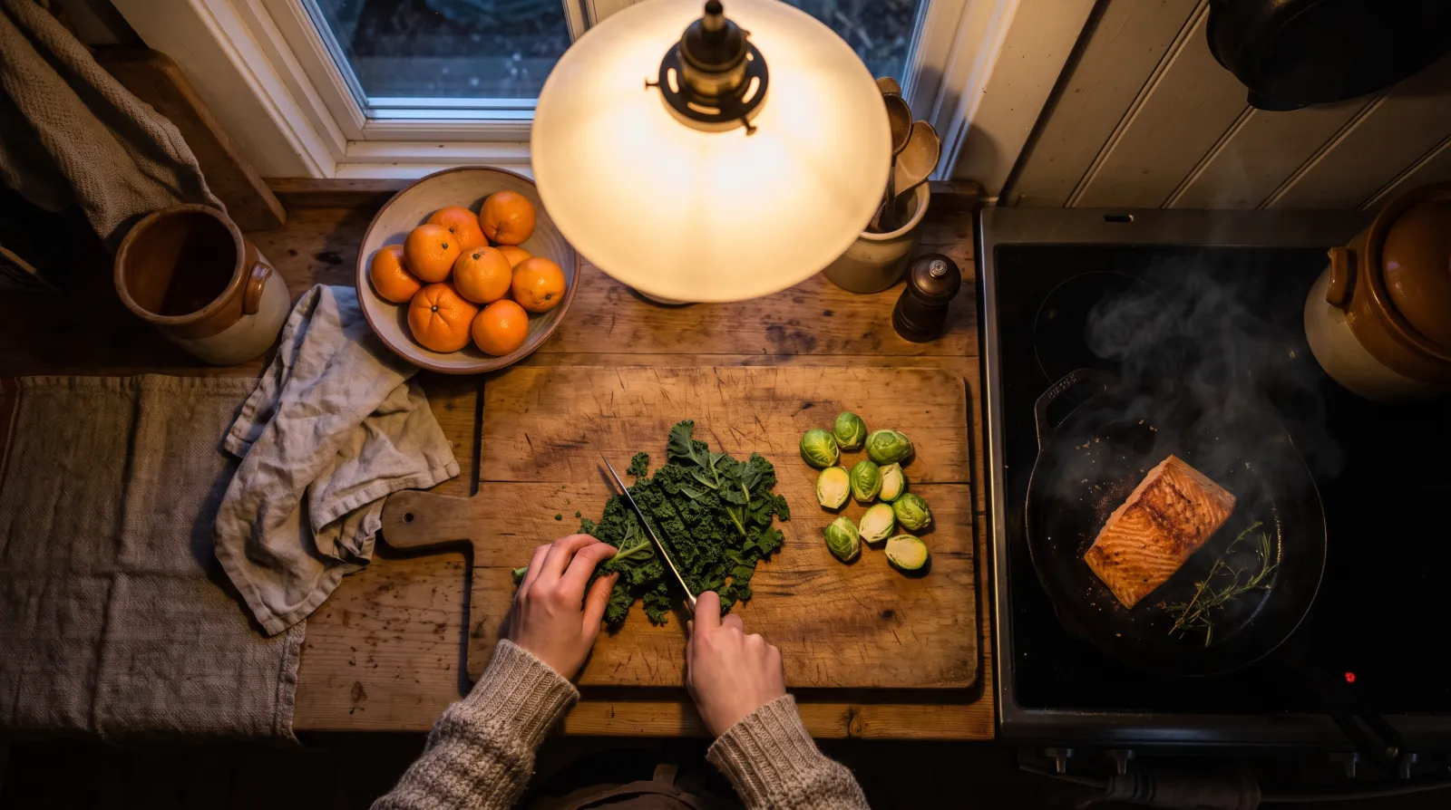 Handen snijden boerenkool en spruitjes op een houten plank in warm keukenlicht voor een wintermaaltijd met vitamines